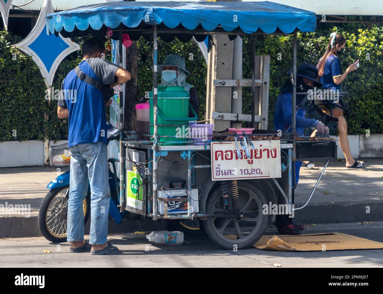 SAMUT PRAKAN, THAÏLANDE, 21 2023 JANVIER, Une femme vend du porc grillé sur un stand mobile dans la rue Banque D'Images