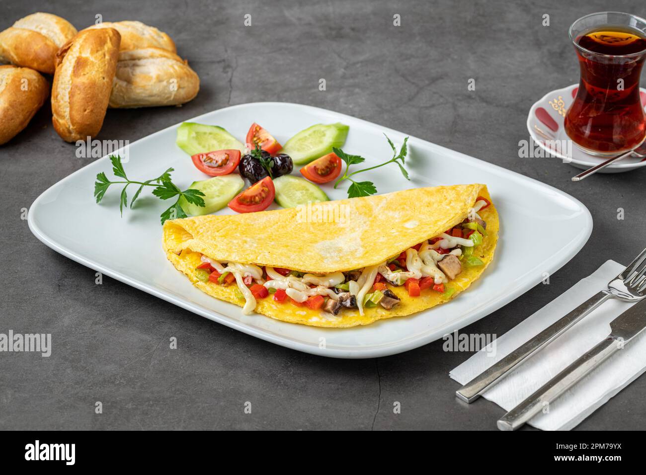 Omelette au fromage, champignons et légumes sur une assiette en porcelaine blanche Banque D'Images