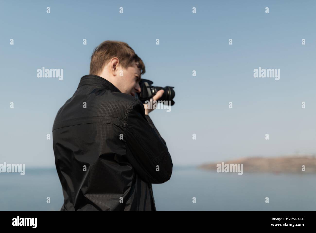 Jeune homme avec un appareil photo. À l'extérieur. Mise au point sélective. Banque D'Images