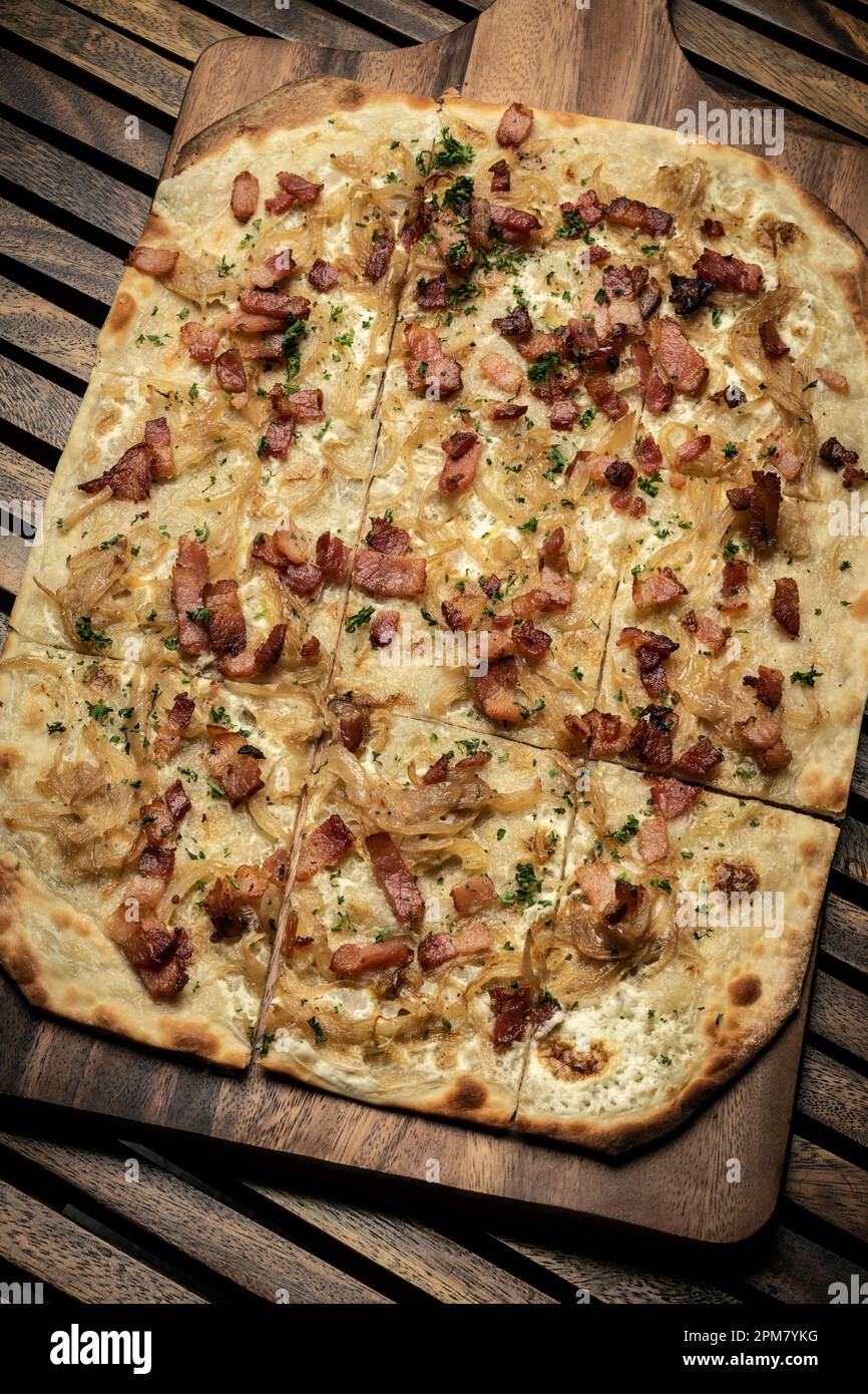 Pizza rectangulaire Flamkuchen tarte flambee avec bacon et poulet sur fond de table en bois Banque D'Images