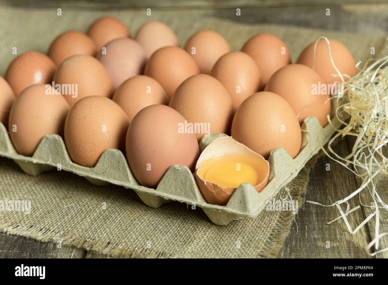 Œufs de poulet fraîchement cueillis sur un fond rustique. Oeufs de poulet dans le foin, scène rurale Banque D'Images