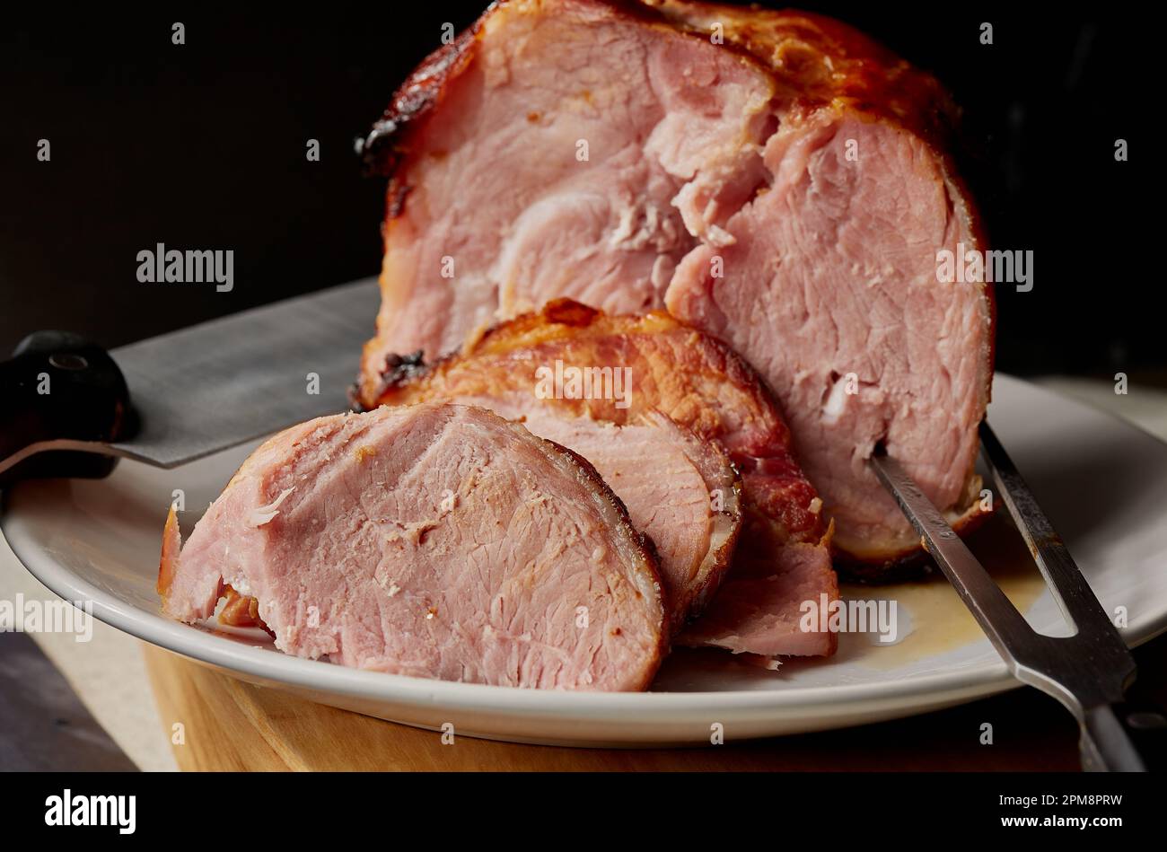 Rôti Gammon qui a été tranché sur une assiette blanche. Banque D'Images