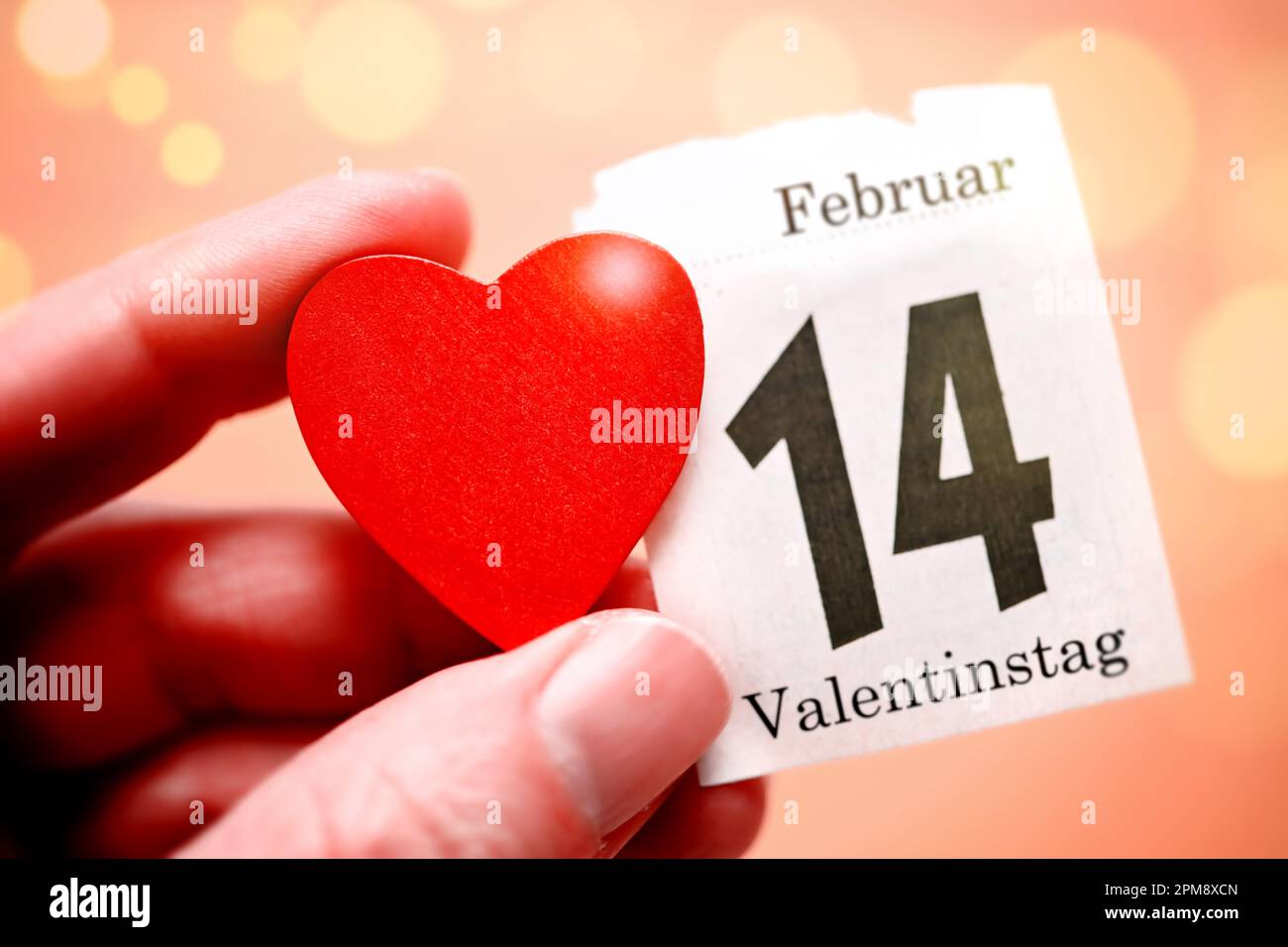 Hält rotes Herz und Kalenderblatt vom 14. Février, Symbolfoto Valentinstag Banque D'Images