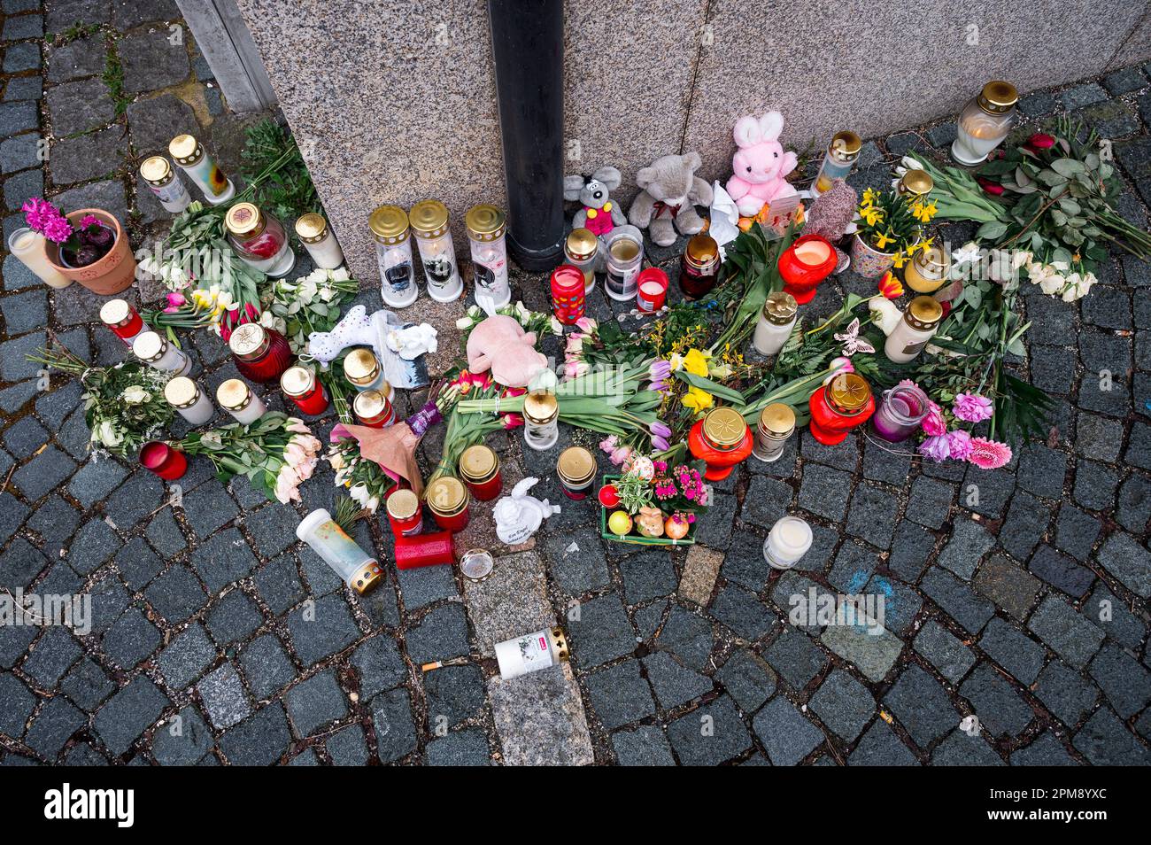 Wunsiedel, Allemagne. 12th avril 2023. Des fleurs, des jouets et des lumières de sépulture se trouvent sur le trottoir à l'angle de la rue menant au Centre des services à l'enfance et à la jeunesse, où une jeune fille de dix ans a été retrouvée morte. Credit: Daniel Vogl/dpa/Alay Live News Banque D'Images