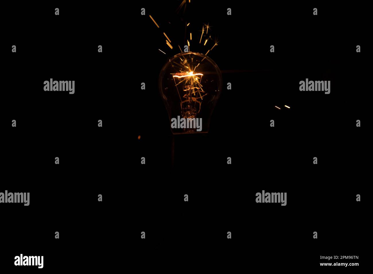 Lumière et étincelles provenant d'une lampe à incandescence qui brûle. Court-circuit. Banque D'Images