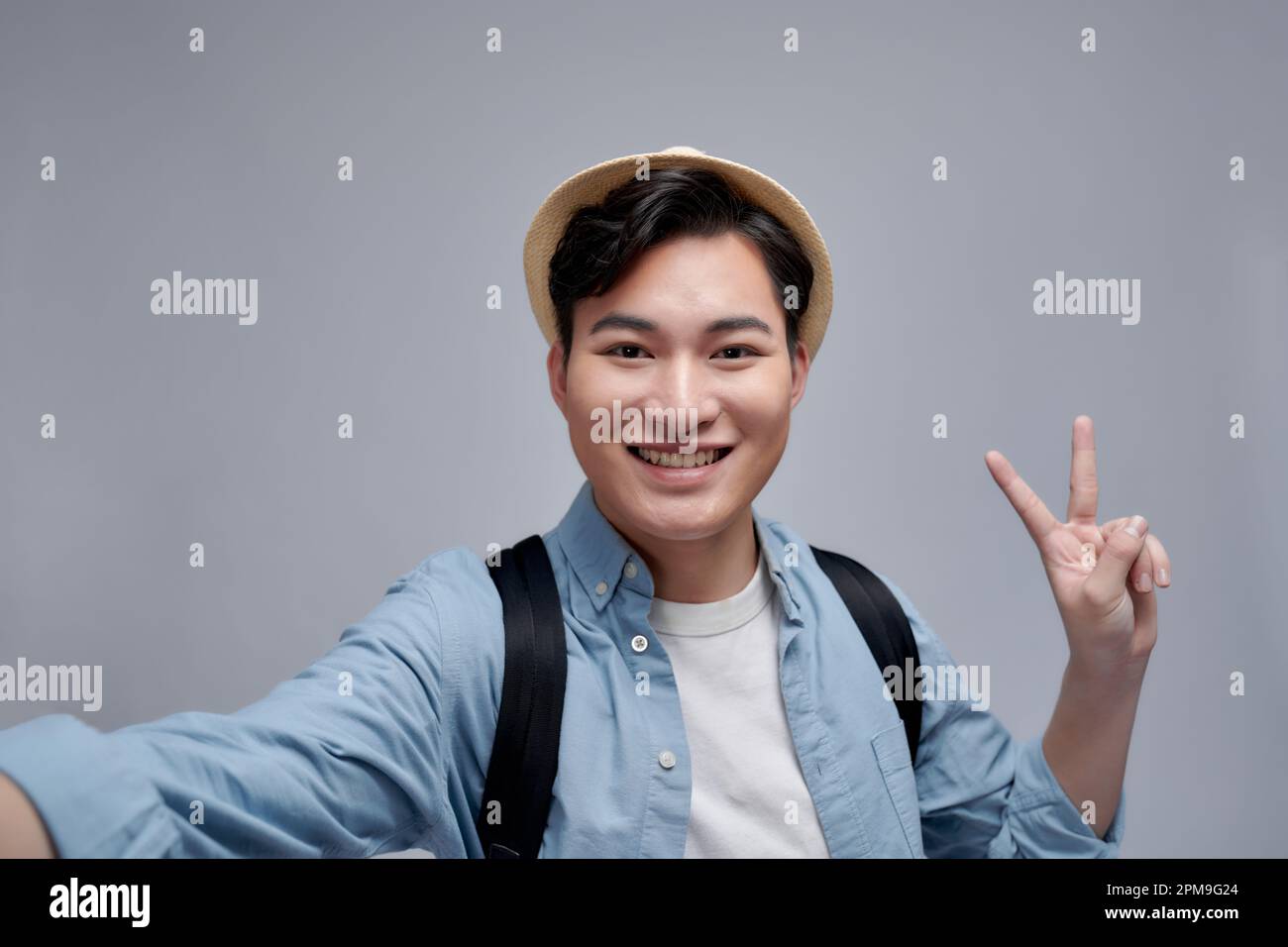 Autoportrait du blogueur de gaifu montrant le symbole de la paix avec deux doigts à la caméra, faisant la vidéo pour son blog Banque D'Images