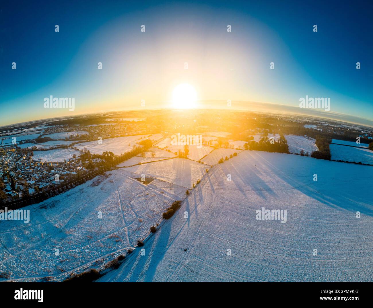 Paysage panoramique vers Cirencester dans les cotswolds au lever du soleil avec la neige. Assemblage à partir de plusieurs photos. Banque D'Images