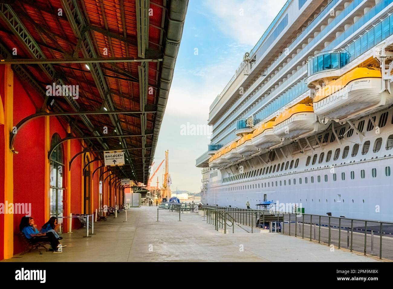 Rio de Janeiro, Brésil - 4 avril 2023 : terminal de croisière. Bateau de croisière Costa Firenze amarré sous un ciel jaune nuageux. Banque D'Images