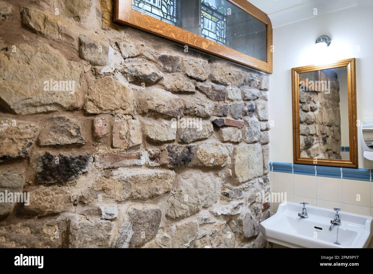 Le bloc de toilettes mâles récemment rénové complète et protège les actifs de grade 1 de l'église St Mary de Castro de Leicester. Banque D'Images