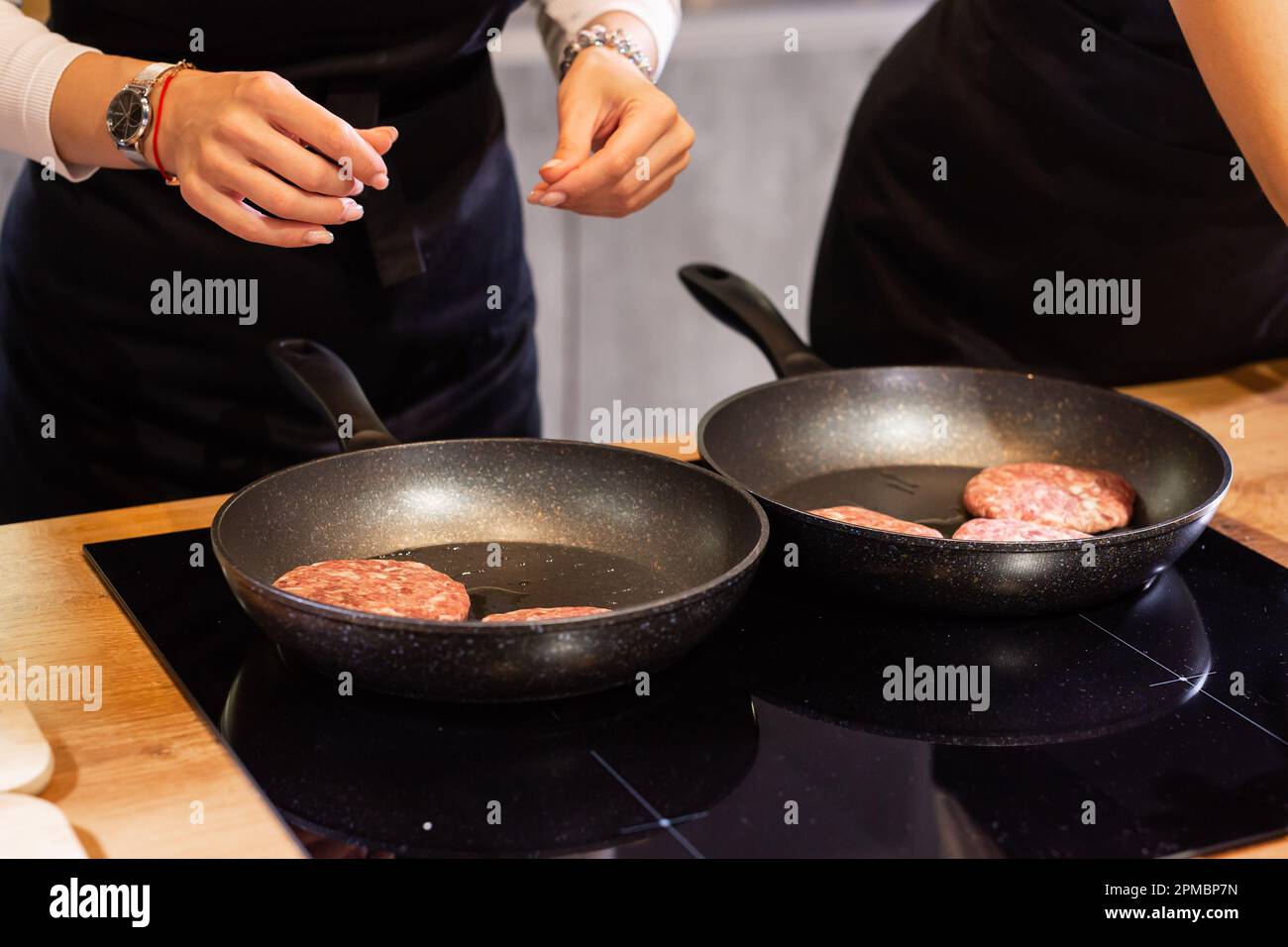 Hamburgers à la viande ou patty en forme de escalopes rôtisant dans l'huile sur une poêle à frire Banque D'Images