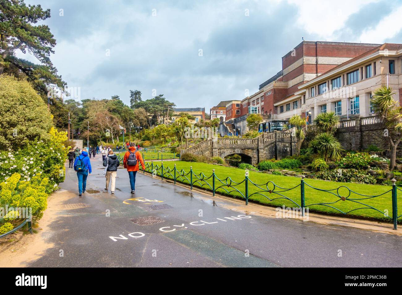 Personnes marchant dans Lower Gardens, un parc public et un espace vert à Bournemouth, Dorset, Royaume-Uni sous un ciel gris, nuageux, orageux Banque D'Images