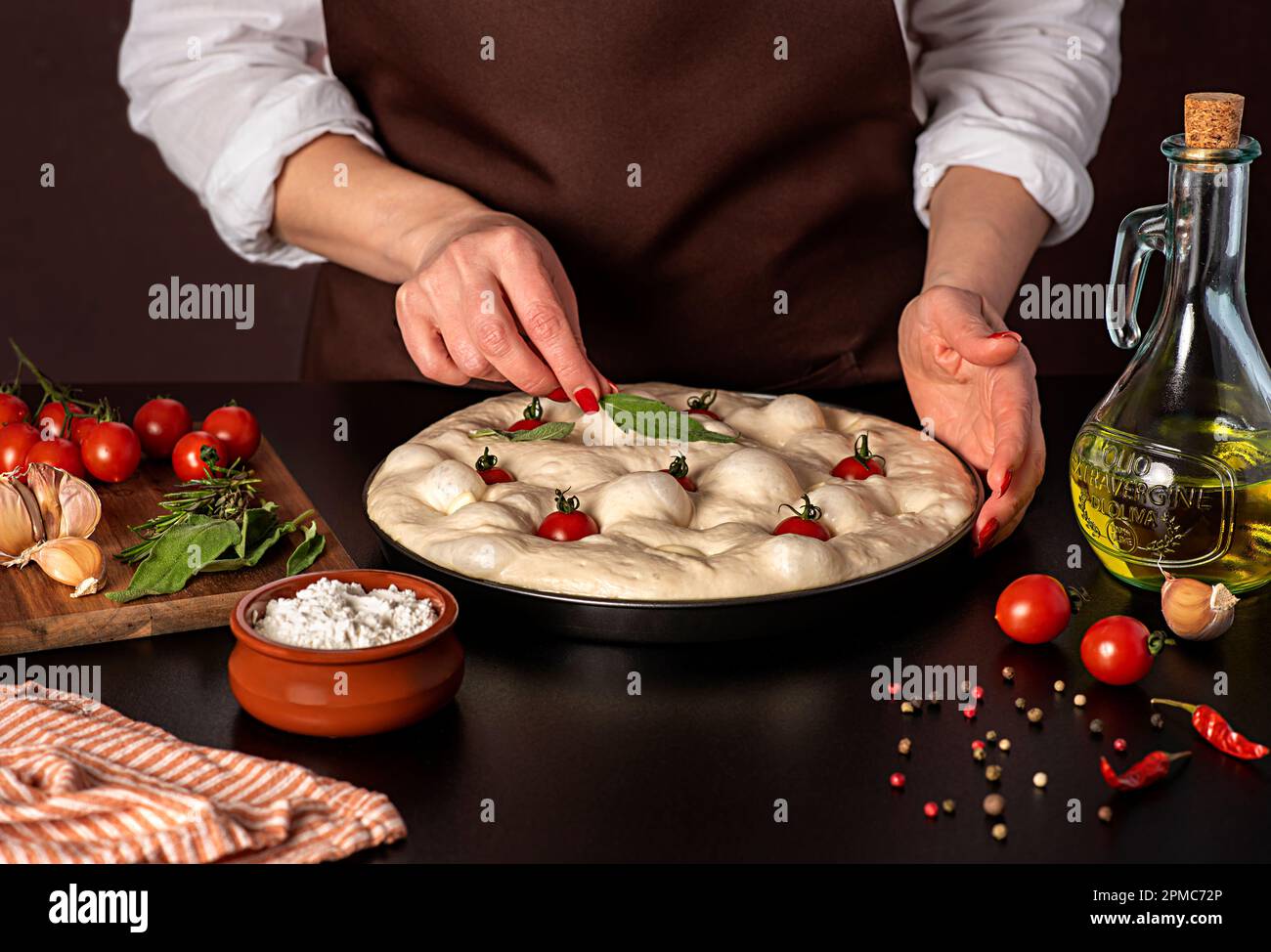 Photographie alimentaire de focaccia de levain brut, tomate, huile d'olive, ail, sauge, farine, poivre, chef, boulangerie, restaurant, cuisine Banque D'Images