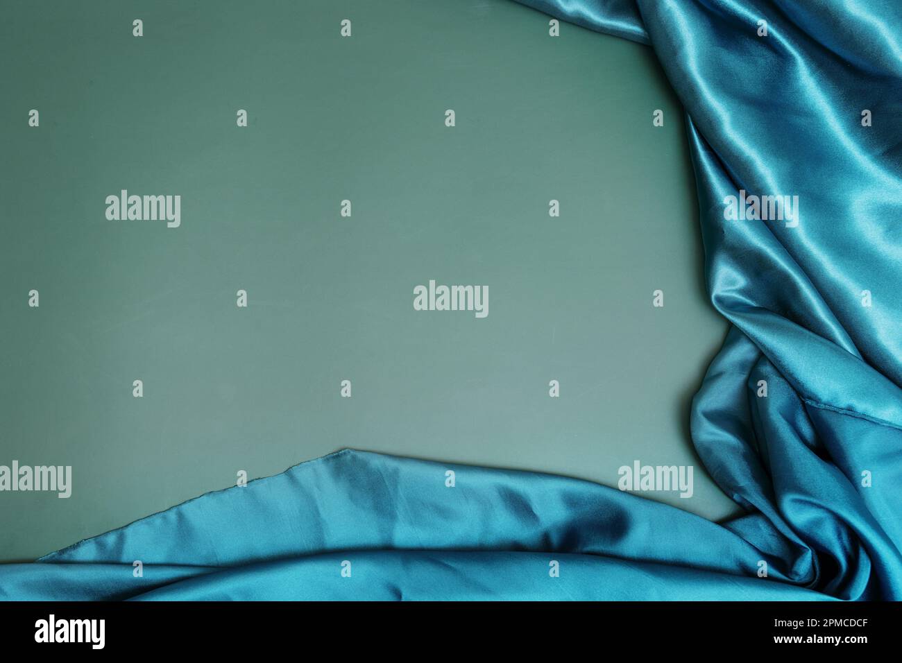 Tissu satiné vert brillant avec plis sur fond vert Uni. Arrière-plan de texture de tissu vectoriel Banque D'Images