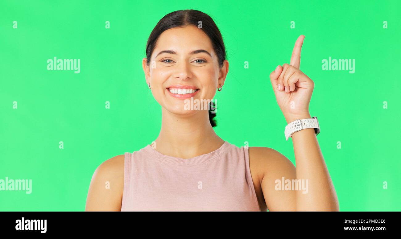 Heureux, femme visage et pointant vers le haut pour montrer la promotion et le placement de produit dans l'écran vert. Bonheur, sourire et modèle geste à la publicité et Banque D'Images