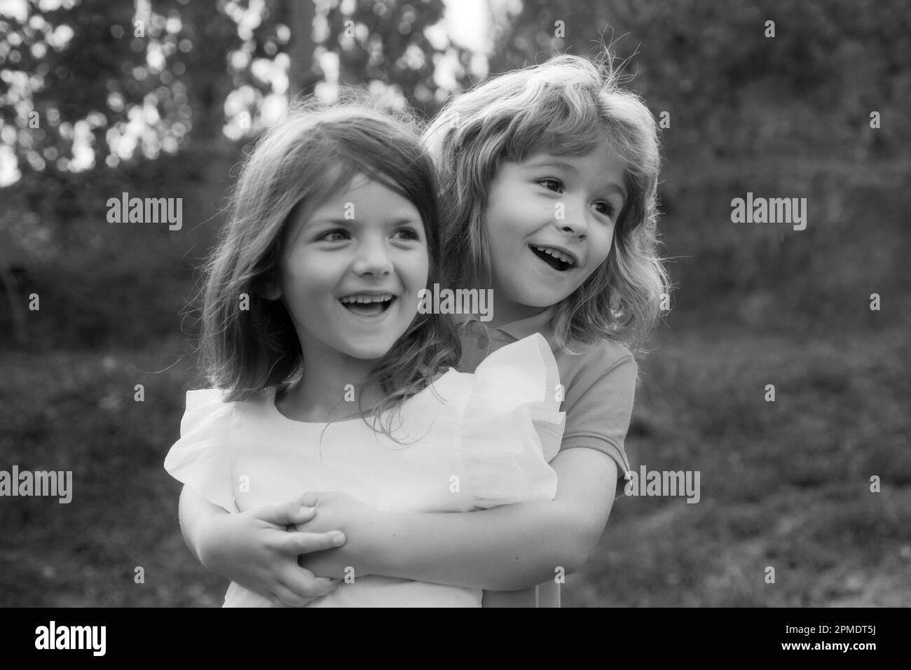 Enfant garçon et fille s'embrassant. Deux petits enfants frère et sœur qui s'embrasent dans le parc. Enfants amis jouant ensemble à l'extérieur. Banque D'Images