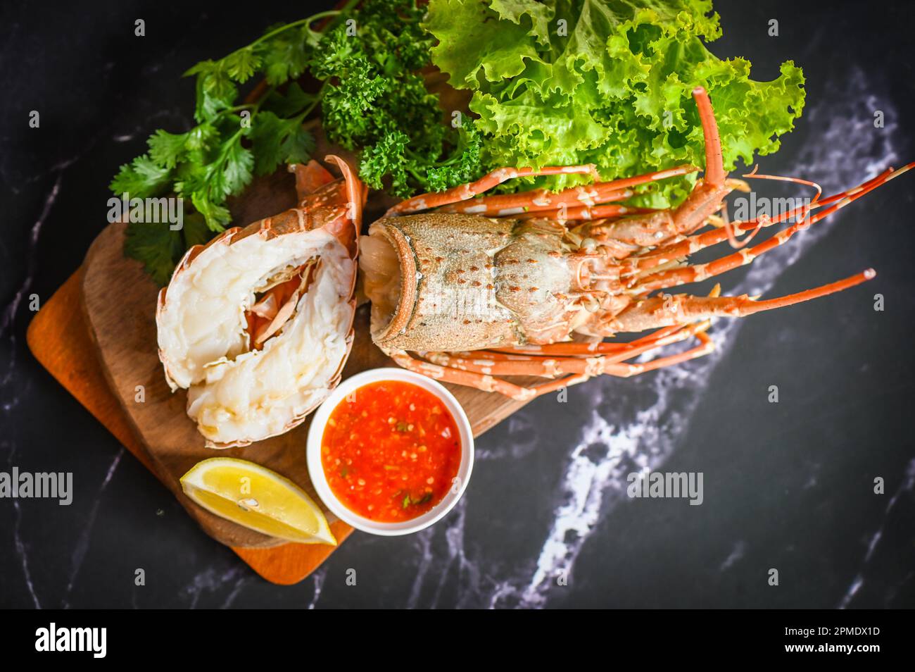 langoustines sur l'assiette, homard frais ou fruits de mer de langouste avec herbes et épices citron coriandre salade de laitue de persil, homard pour la cuisson du foo Banque D'Images langoustines sur l'assiette, homard frais ou fruits de mer de langouste avec herbes et épices citron coriandre salade de laitue de persil, homard pour la cuisson du foo Banque D'Images