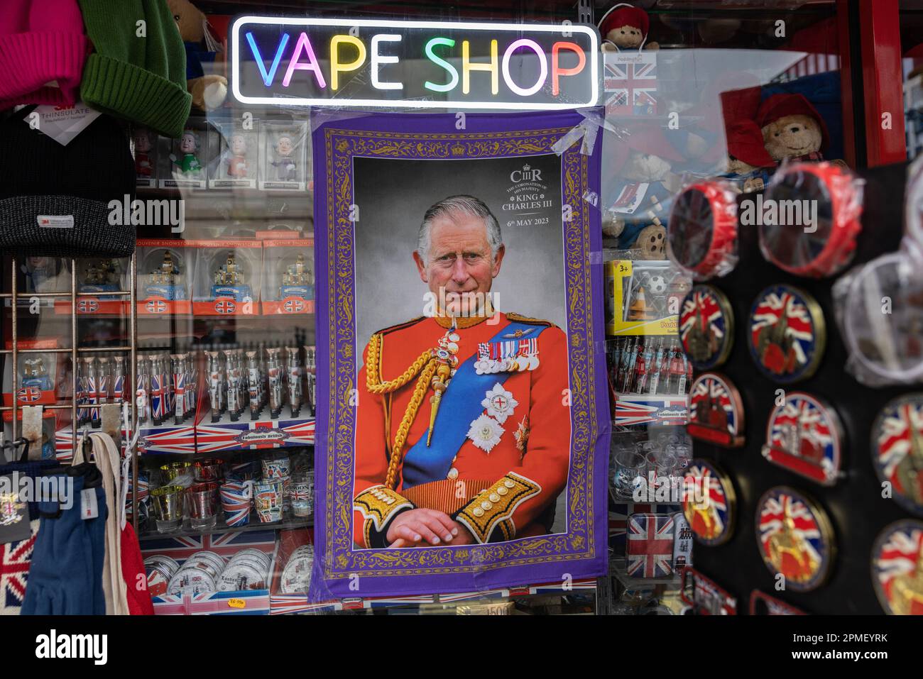Boutique de souvenirs à Londres vendant le torchon King Charles III Coronation, annoncé sous l'enseigne Vape Shop dans une grande fenêtre de magasin de rue, Londres, Royaume-Uni Banque D'Images