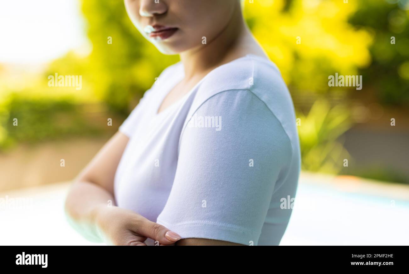 Gros plan d'une femme biraciale portant un t-shirt blanc au-dessus de la piscine dans le jardin Banque D'Images