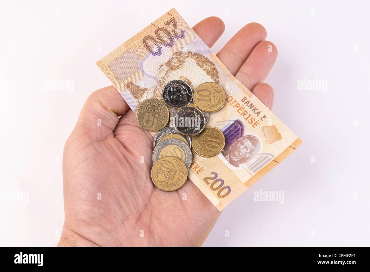 Quelques pièces de monnaie et un billet de banque Lek de monnaie albanaise sur une surface blanche Banque D'Images