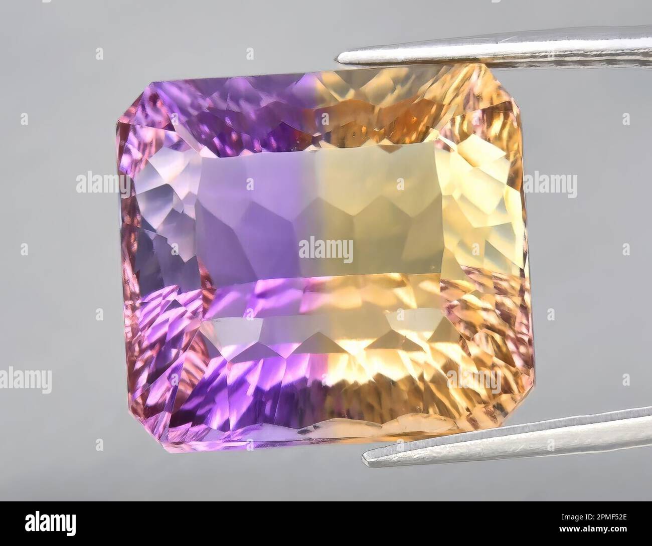 Pierre précieuse naturelle jaune violet amétrine sur fond gris. Variété de quartz violet Banque D'Images