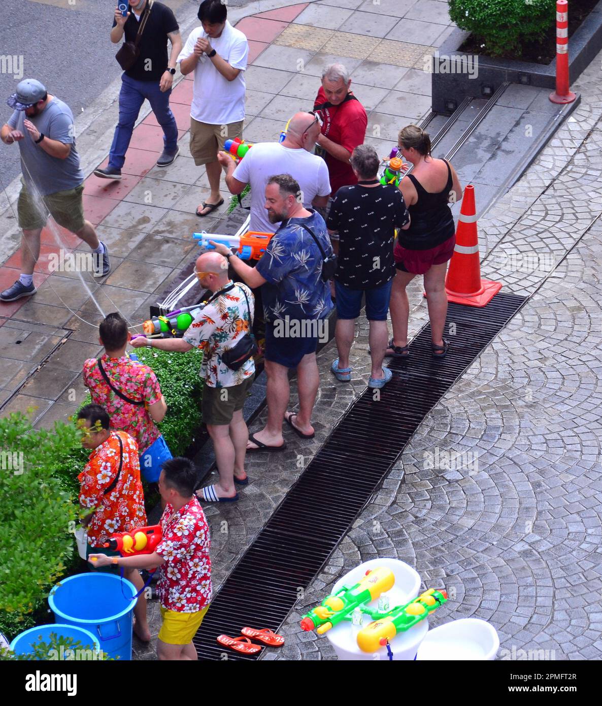 Vue aérienne des gens jouent avec des pistolets d'eau le premier jour du festival d'eau Songkran, ou le nouvel an thaïlandais, le 13th avril 2023, à côté de Surawong Road, Silom district, Bangkok, Thaïlande, Asie. Le festival dure trois jours à Bangkok. Banque D'Images
