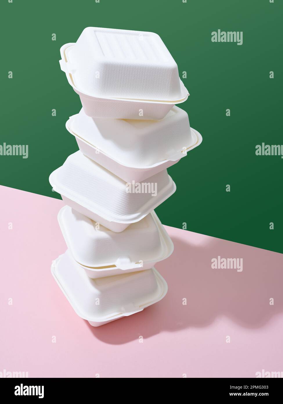 Emballage écologique pour la livraison des aliments. Boîtes à emporter hamburger sur fond vert et rose Banque D'Images