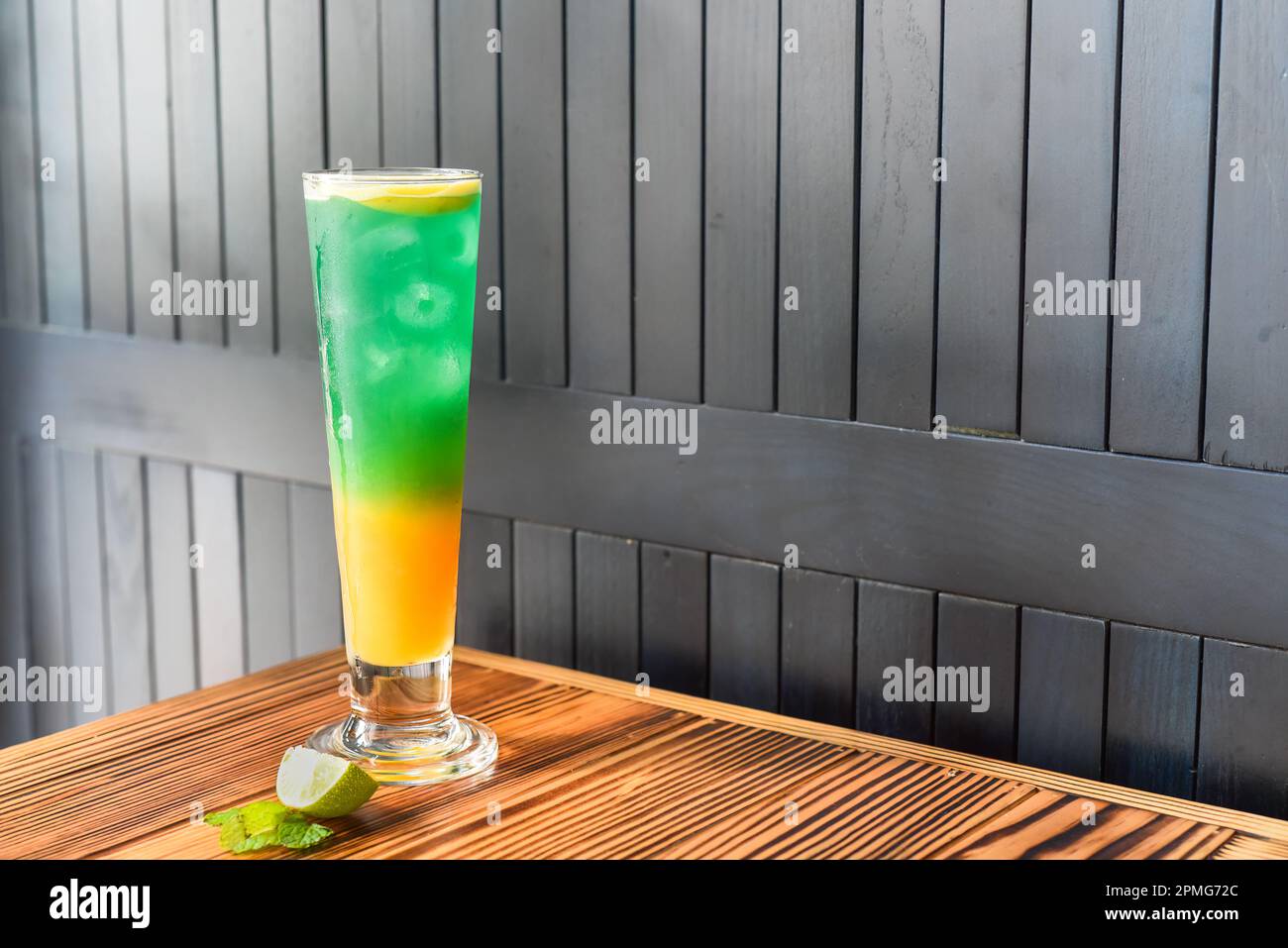Cocktail d'alcool vert-arc-en-ciel sur une table en bois contre un mur  sombre avec espace de copie Photo Stock - Alamy