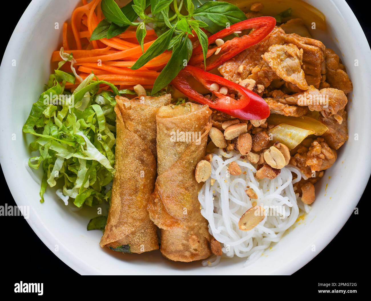 Rouleaux de printemps vietnamiens frits traditionnels au porc servis avec des nouilles de riz, du bœuf frit et des arachides Banque D'Images