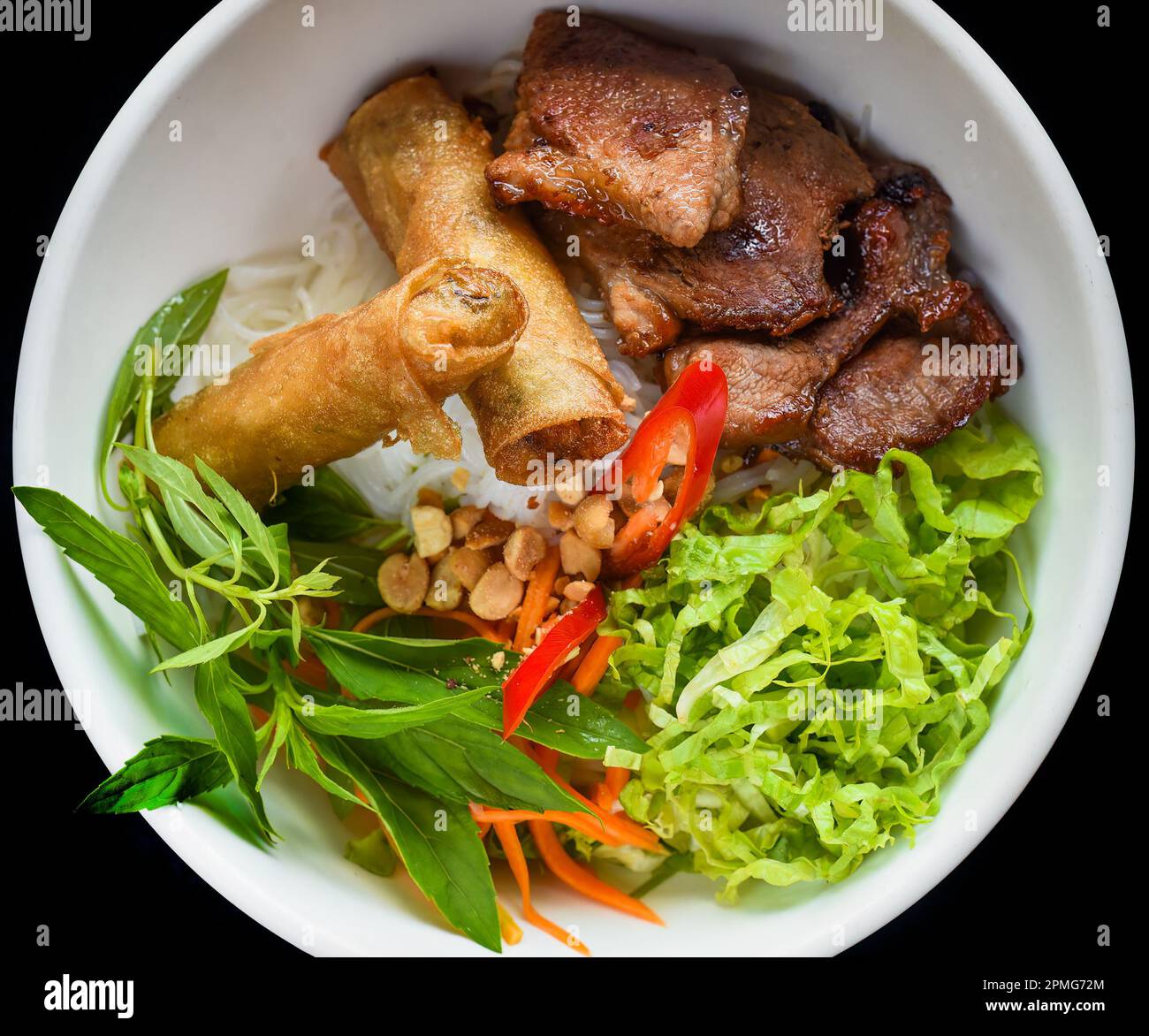Rouleaux de printemps vietnamiens frits traditionnels au porc servis avec des nouilles de riz, du porc frit et des arachides Banque D'Images