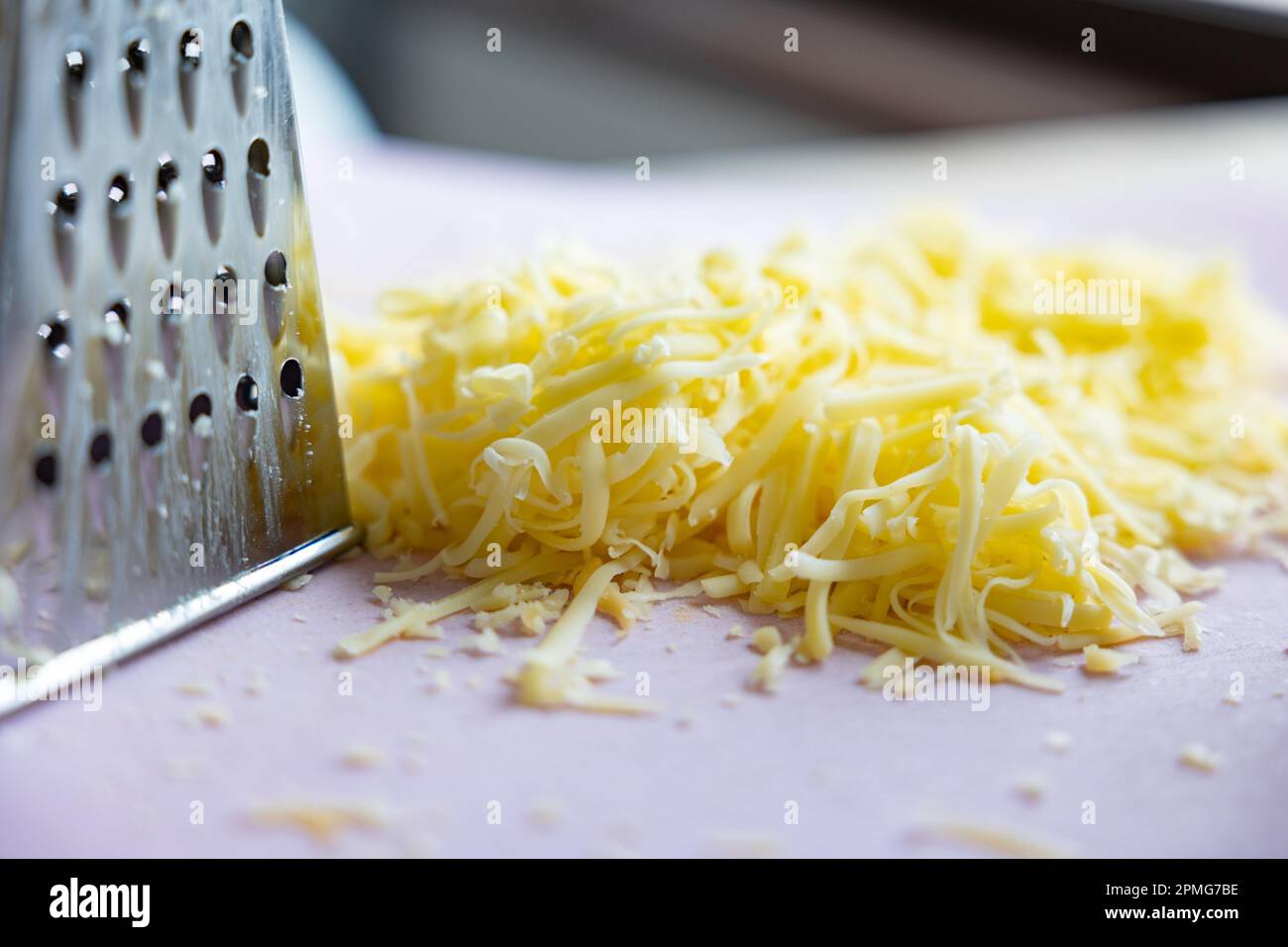 Fromage suisse râpé avec un râpe à boîte : mounds de fromage suisse finement râpé gros plan Banque D'Images