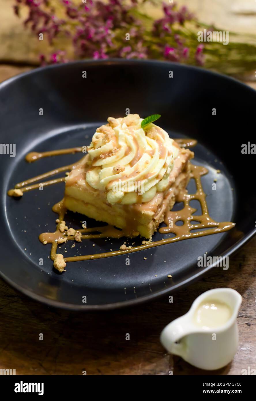 Gâteau Tres sangsues ou trois gâteaux au lait dans une assiette noire sur une table en bois Banque D'Images