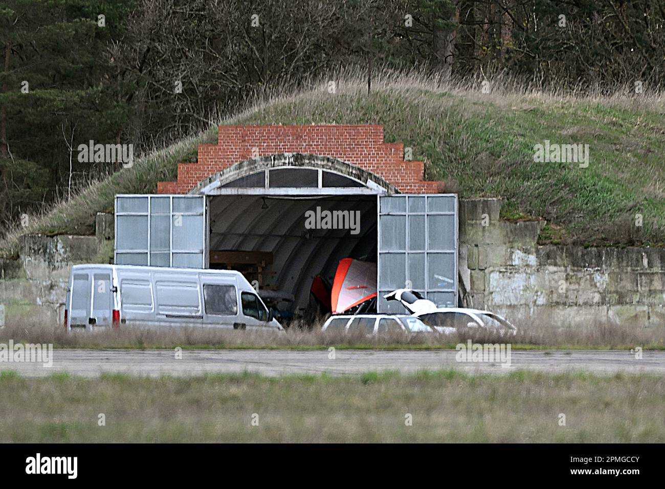 13 avril 2023, Brandebourg, Niedergörsdorf: Derrière la piste, vous pouvez voir un vieux hangar d'avion avec un avion ultraléger. A l'aérodrome 'Altes Lager', il y a eu un accident avec un avion ultraléger. Photo: Michael Bahlo/dpa Banque D'Images