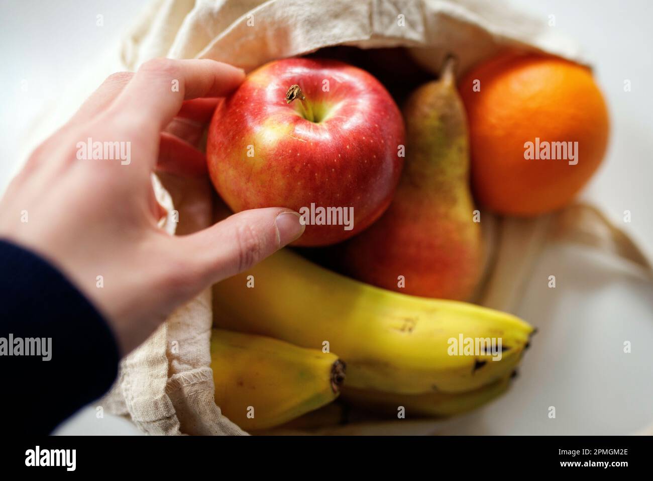 Image symbolique sur la nutrition et les aliments non emballés. Une personne décompresse un achat de fruits non emballés dans un sac en tissu. Berlin, 13 avril 2023. Banque D'Images