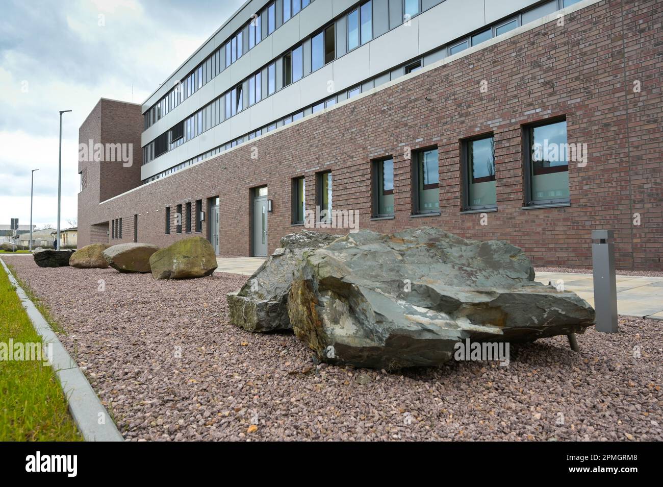 13 avril 2023, Saxe-Anhalt, Halle (Saale): Des blocs irréguliers de divers matériaux en pierre se trouvent devant le nouveau bâtiment de l'Office d'Etat de géologie et d'exploitation minière. Sur l'ancien site de la caserne Fliederweg à Halle/Saale se trouve le nouveau bâtiment avec un environnement de travail de pointe. Photo: Heiko Rebsch/dpa Banque D'Images