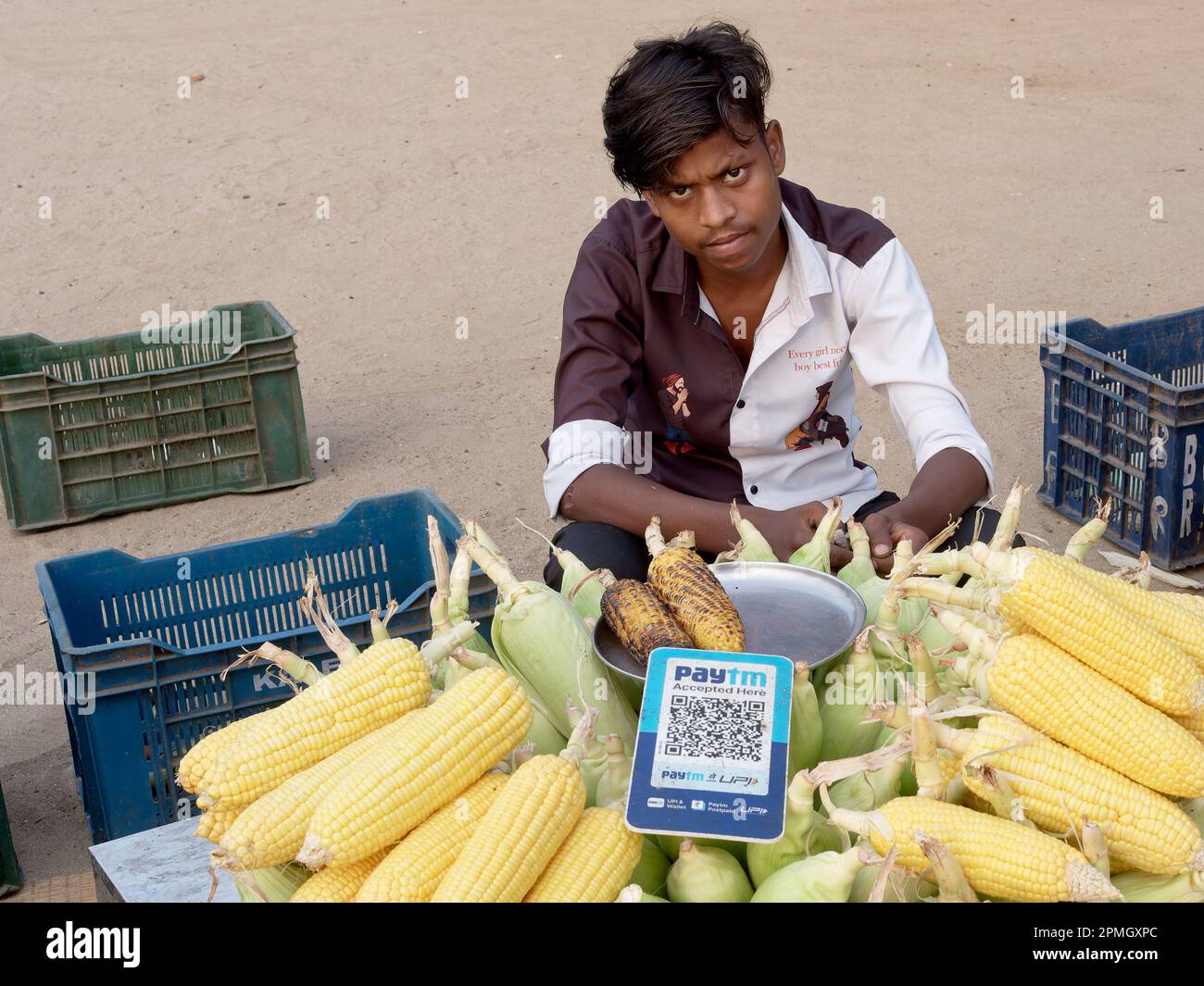 Un jeune Indien qui vend du maïs rôti à Chowpatty Beach, Mumbai, Inde, offre le paiement numérique (Paytm) via le code QR Banque D'Images