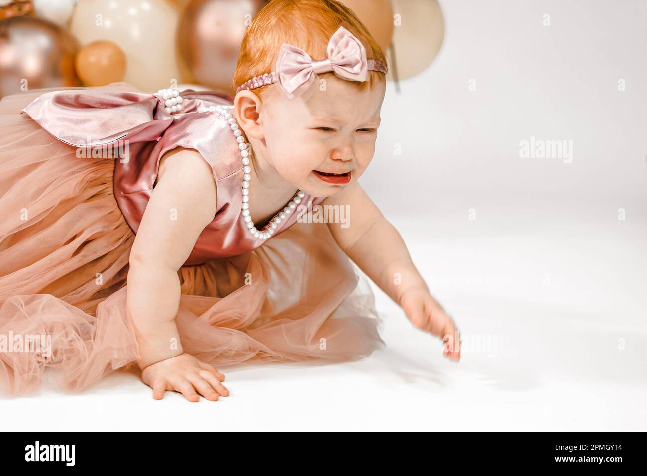 Petite pleurs malheureux redhead bébé fille fête le premier anniversaire. Fête de famille de 1 ans séance photo professionnelle en studio photo. Adora mignon Banque D'Images