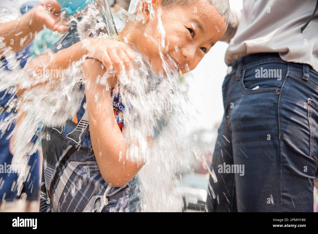 Garçon baigné d'eau au festival de l'eau de Songkran Chiang Mai, Thaïlande Banque D'Images
