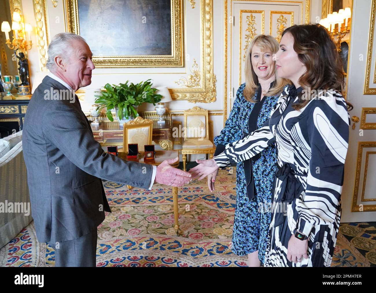 Le roi Charles III salue Anne Jessopp, chef de la direction de la monnaie royale (au centre) et Rebecca Morgan, directrice, avant d'être présentée avec des pièces de monnaie couronnement nouvellement frappées au château de Windsor, dans le Berkshire. Un portrait couronné du roi sera pour la première fois sur une nouvelle gamme de pièces commémoratives créées pour célébrer le prochain couronnement. La collection, qui comprend une pièce de 50p et £5, sera libérée plus tard ce mois-ci avant la célébration historique de 6 mai. Date de la photo: Jeudi 13 avril 2023. Banque D'Images