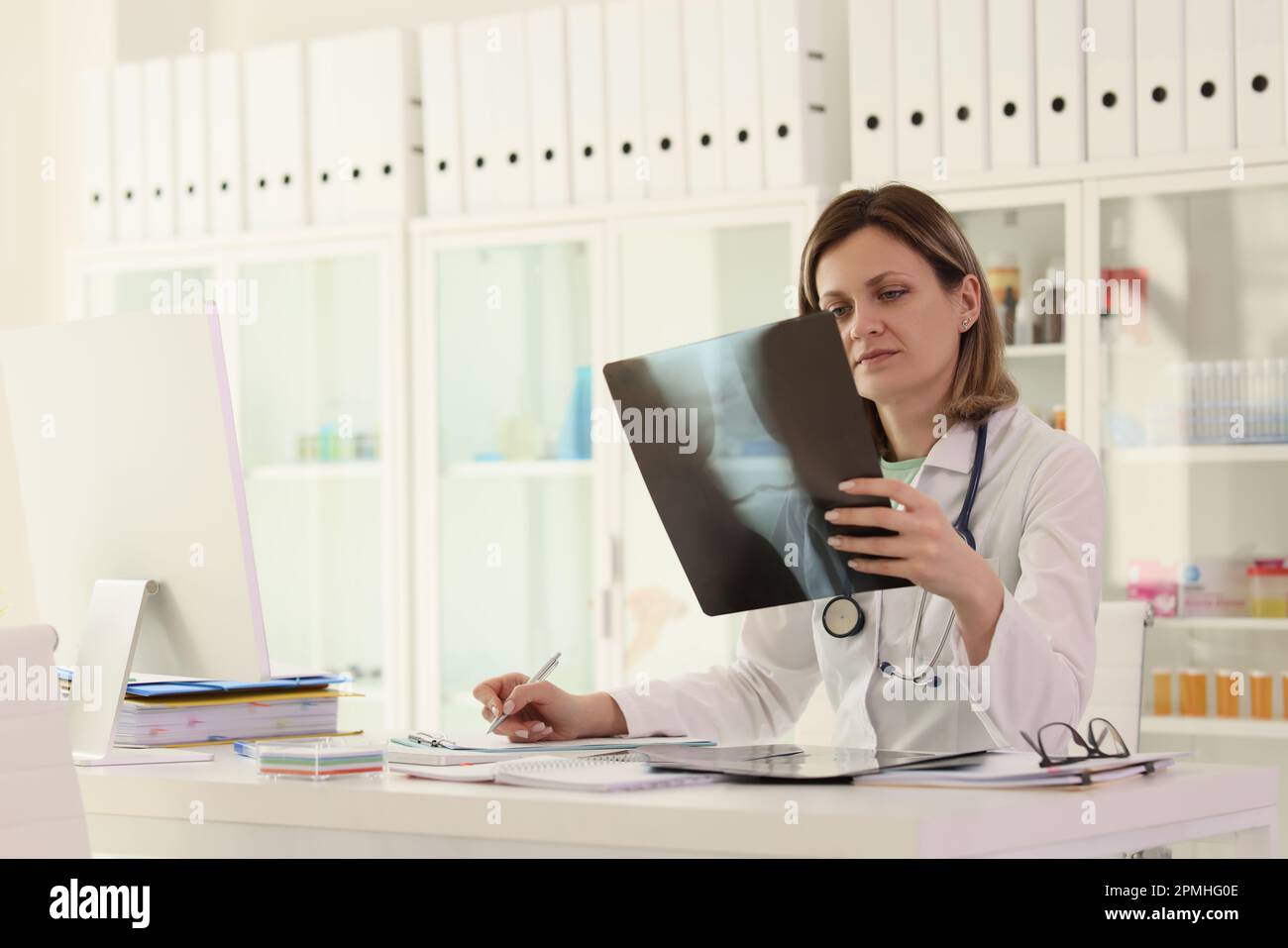La femme étudie l'image radiographique des notes de prise de joint Banque D'Images