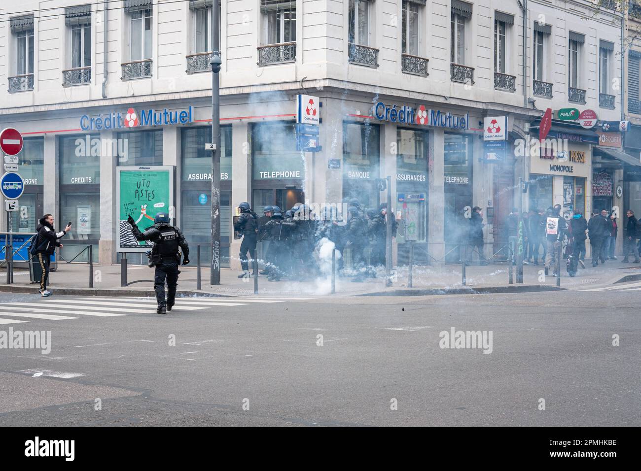 France, Lyon, 2023-04-06. La police s'est rassemblée sous gaz lacrymogène devant une banque lors de la manifestation contre la réforme des retraites. Banque D'Images