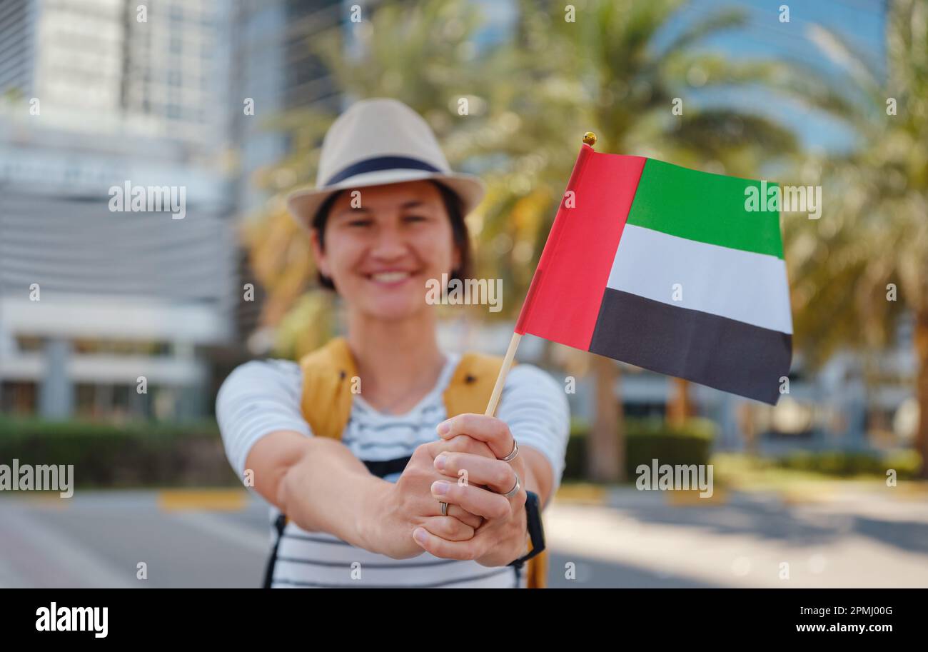 Bonne jeune femme asiatique avec sac à dos et chapeau avec drapeau des  Émirats arabes Unis contre les gratte-ciels pittoresques d'Abu Dhabi.  Immigration, éducation des étudiants et arabe Photo Stock - Alamy