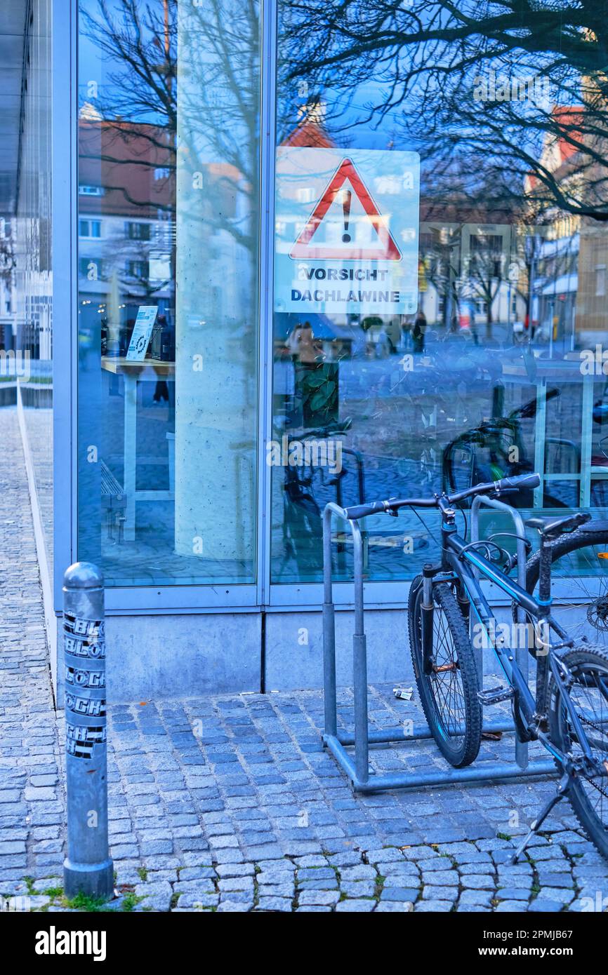 Vorsicht Dachlavine, panneau d'avertissement derrière la façade vitrée de la bibliothèque de la ville sur Rathausplatz à Ulm, Bade-Wurtemberg, Allemagne, Europe. Banque D'Images