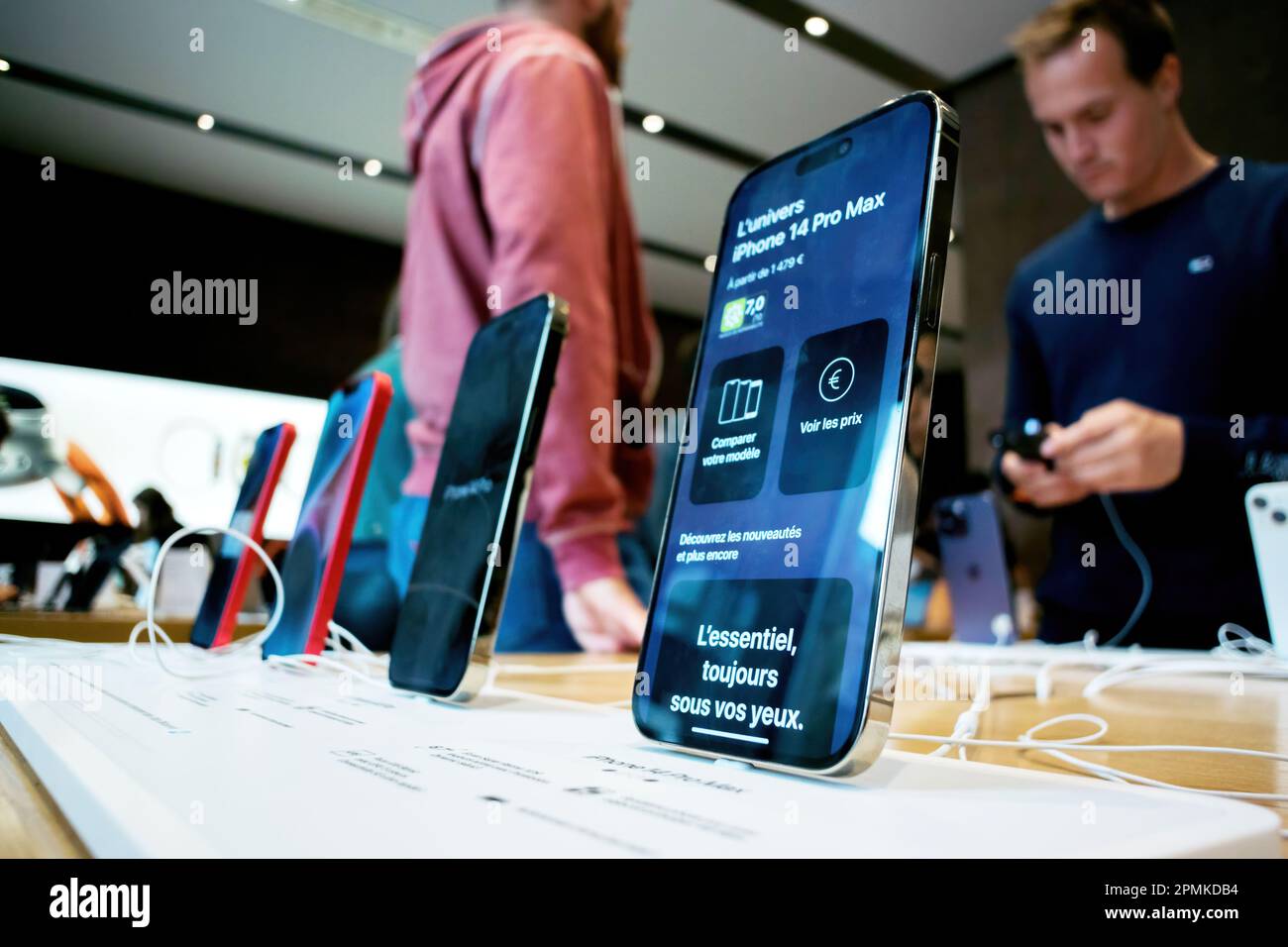 Paris, France - 22 septembre 2022 : chargement de l'iPhone 14 Pro d'Apple sur fond d'Apple Store avec écran et nom affiché - adultes et enfants testant en arrière-plan de nouveaux appareils Banque D'Images