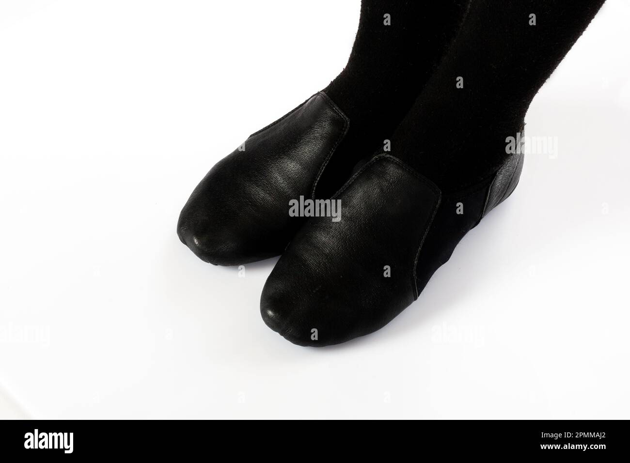 Black Jazz CORRIGER la position des pieds debout sur un fond blanc isolé gros plan de la jeune danseuse de ballet montrant divers classiques de ballet Banque D'Images