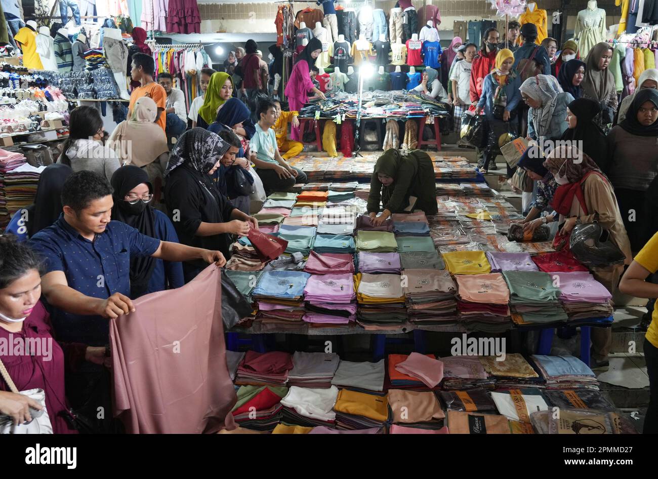 People shop at the Tanah Abang market during Ramadan in Jakarta, Indonesia, Friday, April 14, 2023. Indonesians flock markets and shopping malls in the capital as they shop for food and new clothing in preparation for Eid al-Fitr holiday that marks the end of the holiest month in Islamic calendar. (AP Photo/Achmad Ibrahim) Banque D'Images