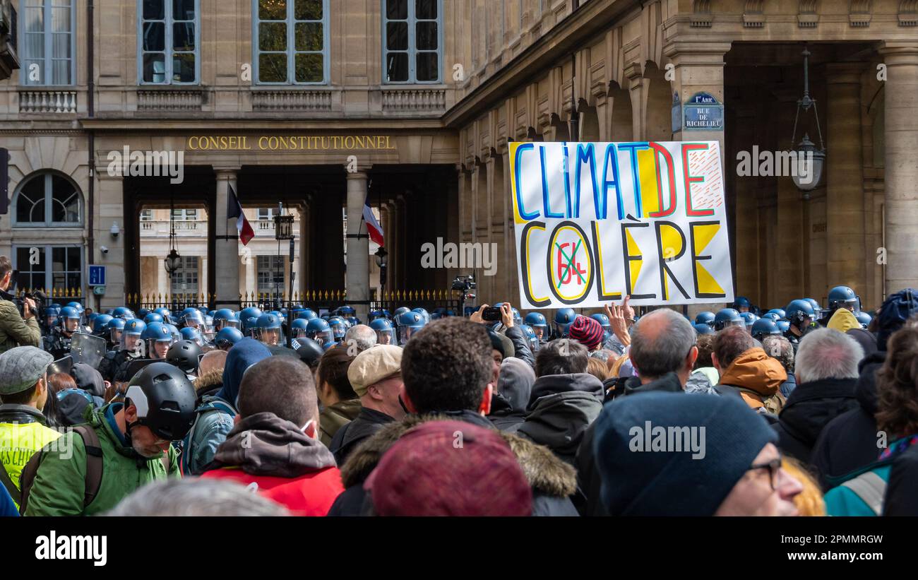 Les manifestants français contre la réforme de la retraite avec un panneau "climat de colère" passent près du Conseil constitutionnel sous protection policière Banque D'Images