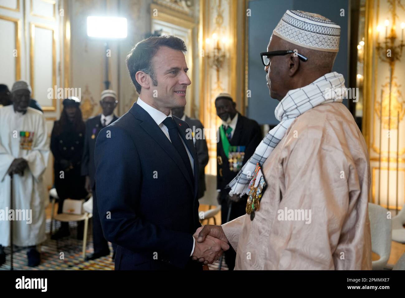 Paris, France. 14th avril 2023. Vendredi, le président français Emmanuel Macron tremble la main avec des vétérans sénégalais de la guerre, 14 avril 2023 à l'Elysée à Paris. Certains des derniers survivants en France d'un corps d'infanterie de l'époque coloniale qui a recruté des dizaines de milliers de soldats africains pour combattre dans les guerres françaises à travers le monde pourront vivre leurs derniers jours avec des membres de la famille de retour en Afrique après un demi-tour du gouvernement français plus tôt année sur leurs droits à pension. Photo de Lewis Joly/Pool/ABACAPRESS.COM crédit: Abaca Press/Alay Live News Banque D'Images