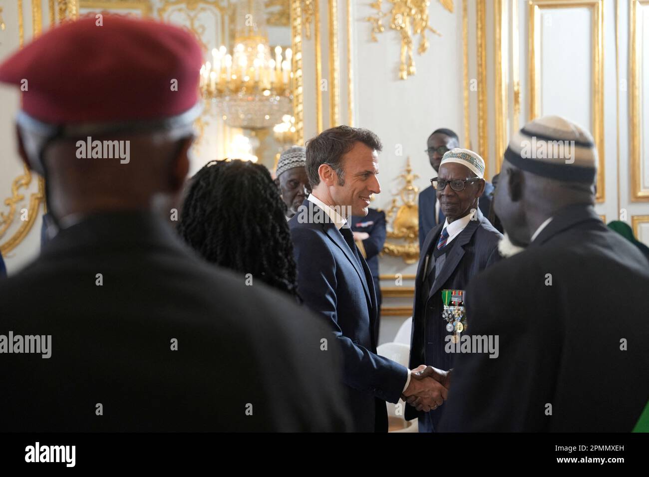 Paris, France. 14th avril 2023. Vendredi, le président français Emmanuel Macron tremble la main avec des vétérans sénégalais de la guerre, 14 avril 2023 à l'Elysée à Paris. Certains des derniers survivants en France d'un corps d'infanterie de l'époque coloniale qui a recruté des dizaines de milliers de soldats africains pour combattre dans les guerres françaises à travers le monde pourront vivre leurs derniers jours avec des membres de la famille de retour en Afrique après un demi-tour du gouvernement français plus tôt année sur leurs droits à pension. Photo de Lewis Joly/Pool/ABACAPRESS.COM crédit: Abaca Press/Alay Live News Banque D'Images