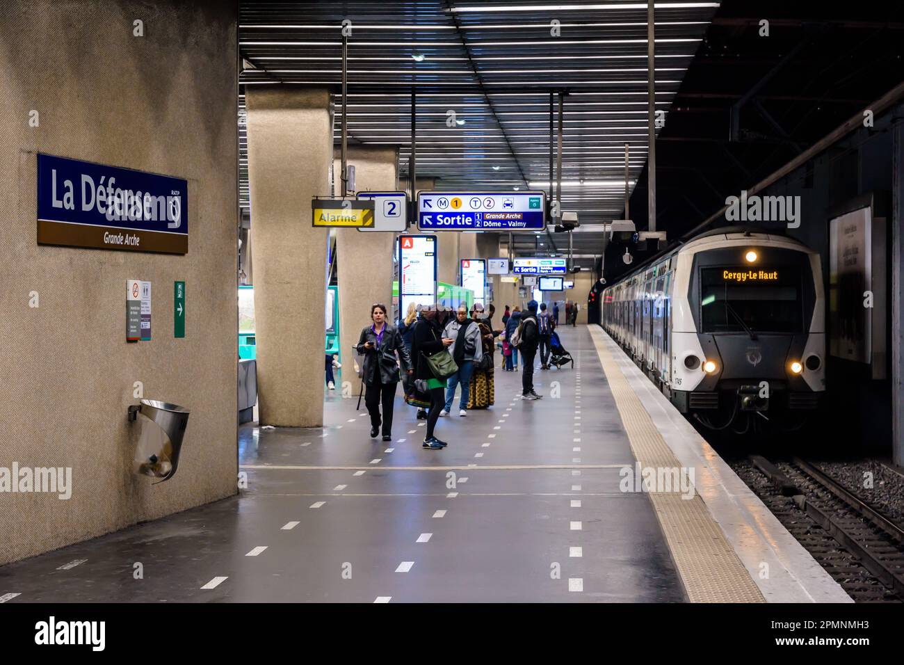 Les passagers se préparent à monter à bord du train arrivant à la plate-forme de la station de métro la Défense sur la ligne A du réseau de transports en commun RER. Banque D'Images