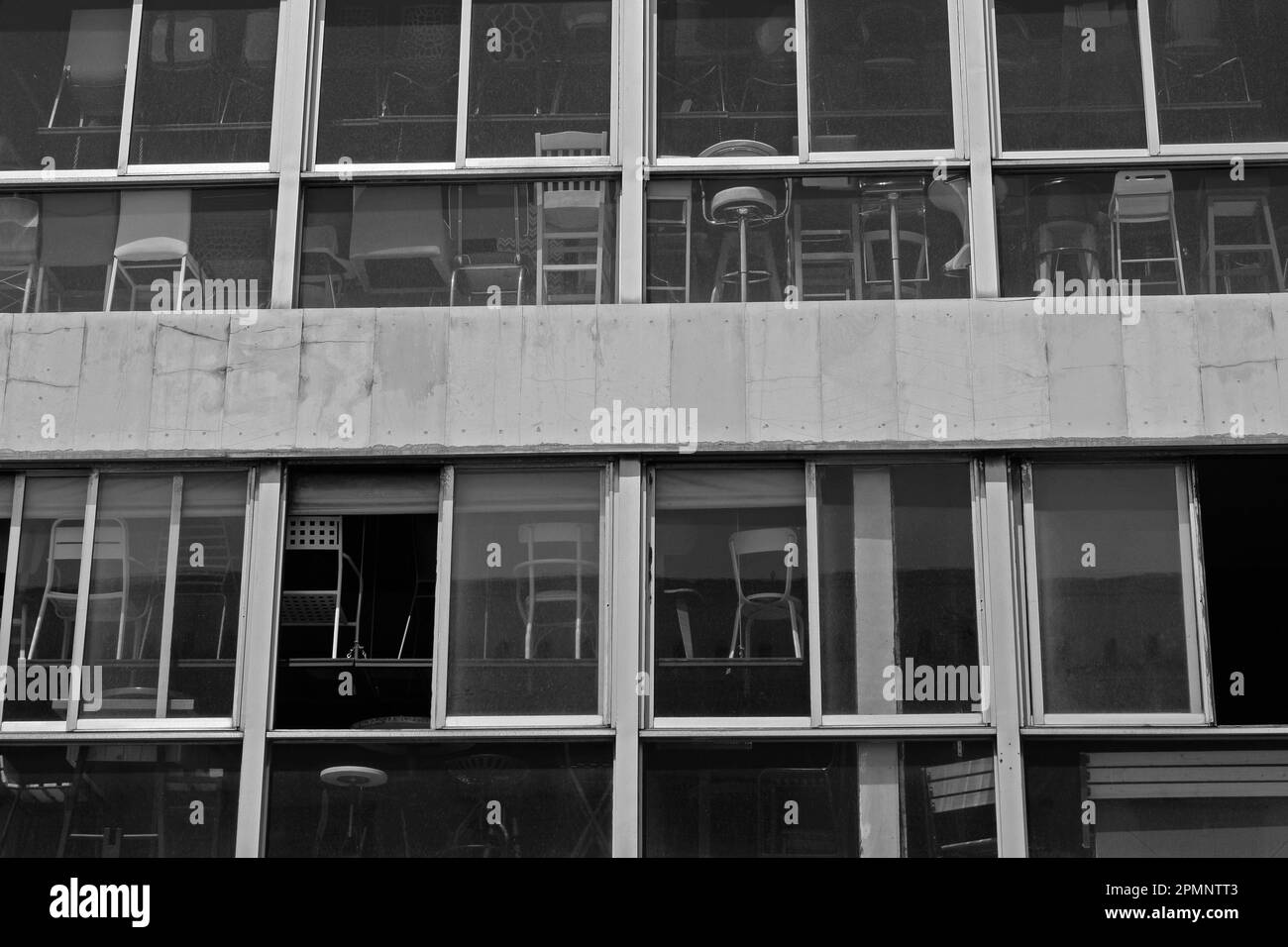 Chaises à vendre derrière des fenêtres poussiéreuses. Noir et blanc. Banque D'Images